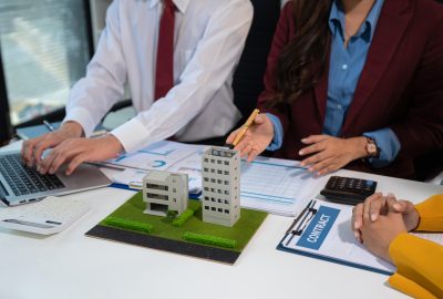 House model with agent asking costumer for contract to buy, get insurance or loan real estate or property.